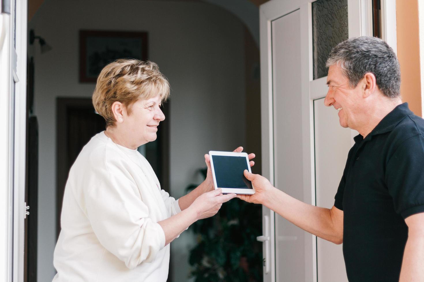 donne che salutano gli uomini alla porta con acquisto di gadget elettronici con ordine online foto