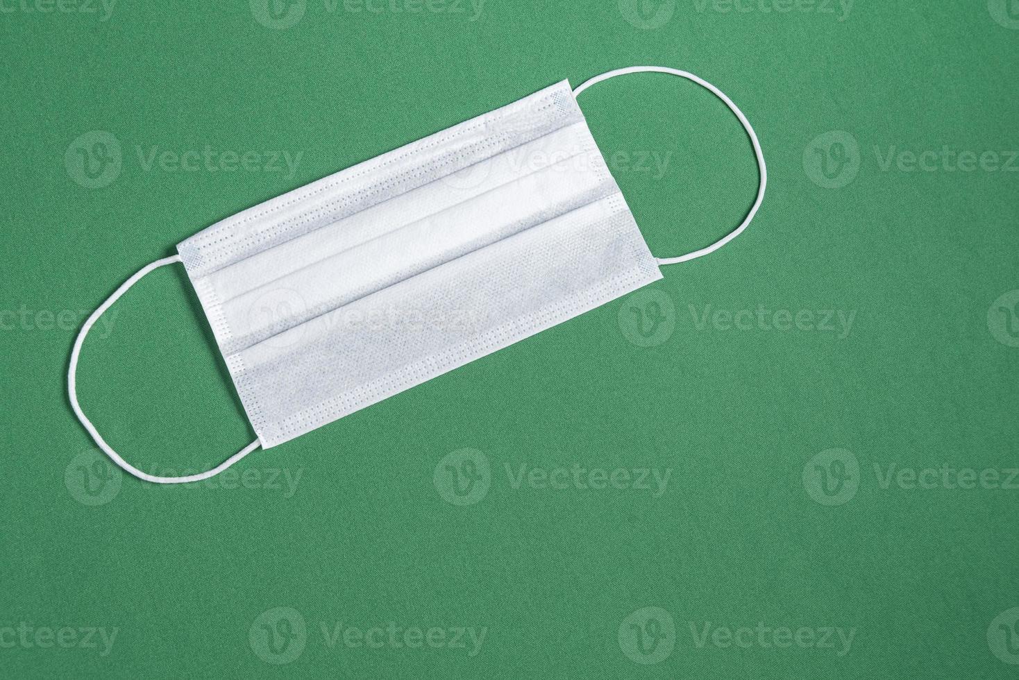 maschera chirurgica su sfondo verde minimalista foto