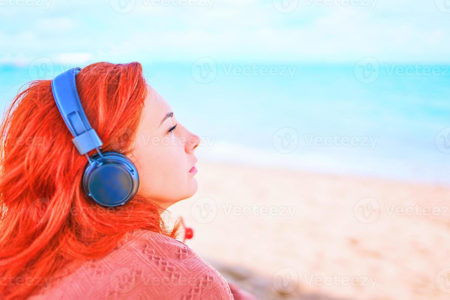 bella donna che ascolta la musica sulla spiaggia. foto