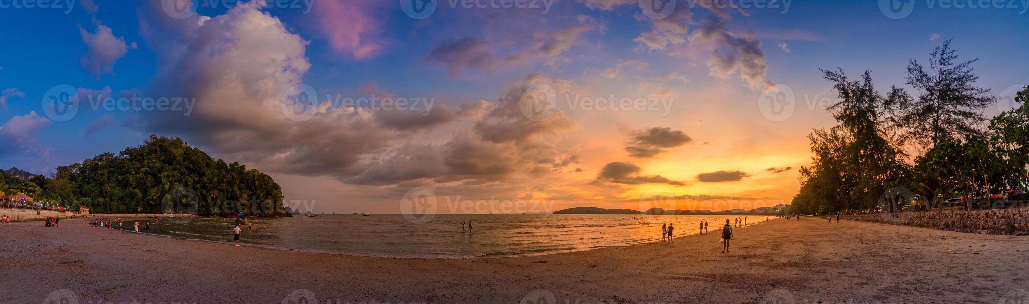 ao nang krabi thailandia la spiaggia è piena di gente la sera. foto panoramica a luce dorata