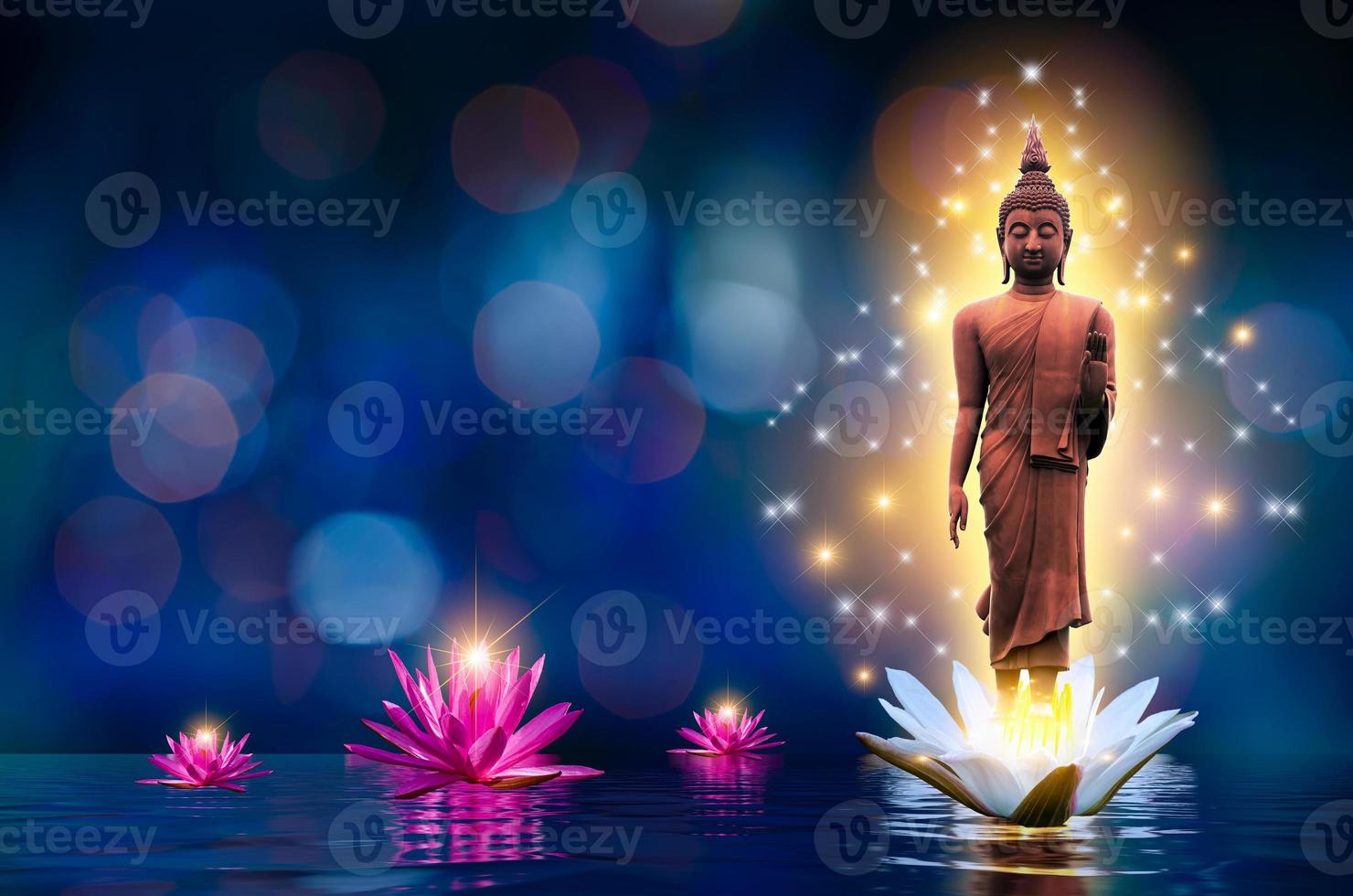 la statua del Buddha si erge su un loto bianco e rosa nell'acqua. sfondo blu bokeh. foto