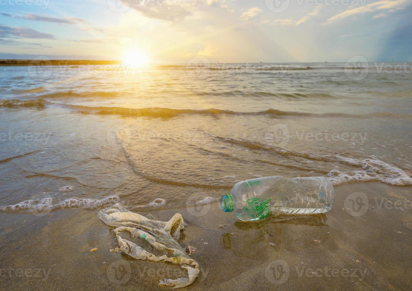 spazzatura la bottiglia di plastica del mare della spiaggia si trova sulla spiaggia e inquina il mare e la vita della vita marina ha versato immondizia sulla spiaggia della grande città. bottiglie di plastica sporche usate vuote foto