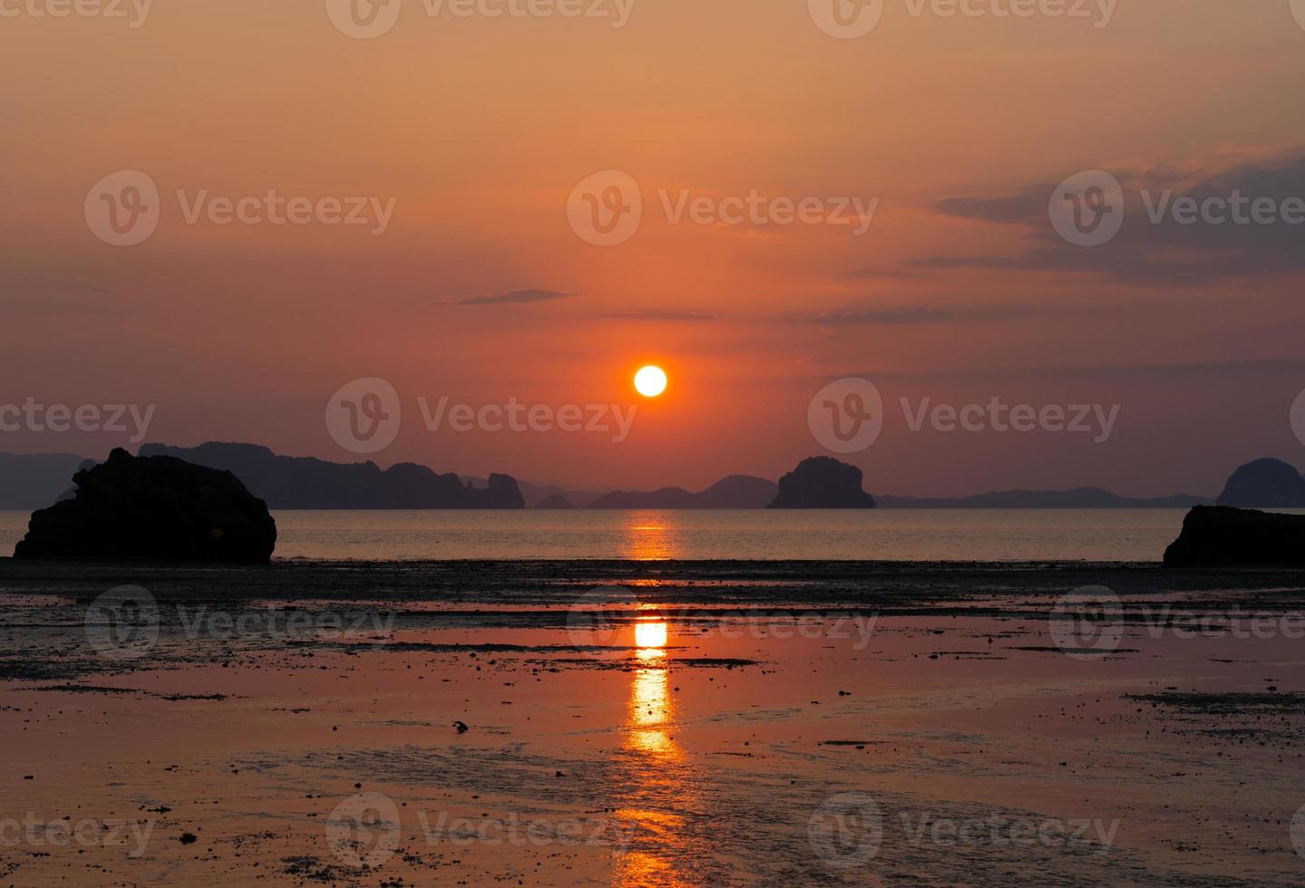 bellissimo tramonto sulla spiaggia in estate con riflesso del sole nell'acqua foto