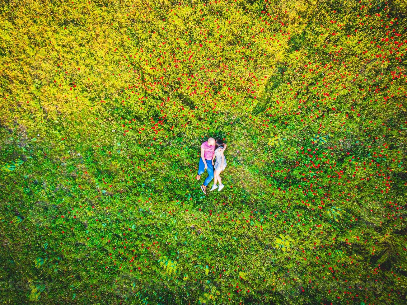 coppia che si bacia in natura soleggiata campo verde all'aperto insieme dal punto di vista aereo foto