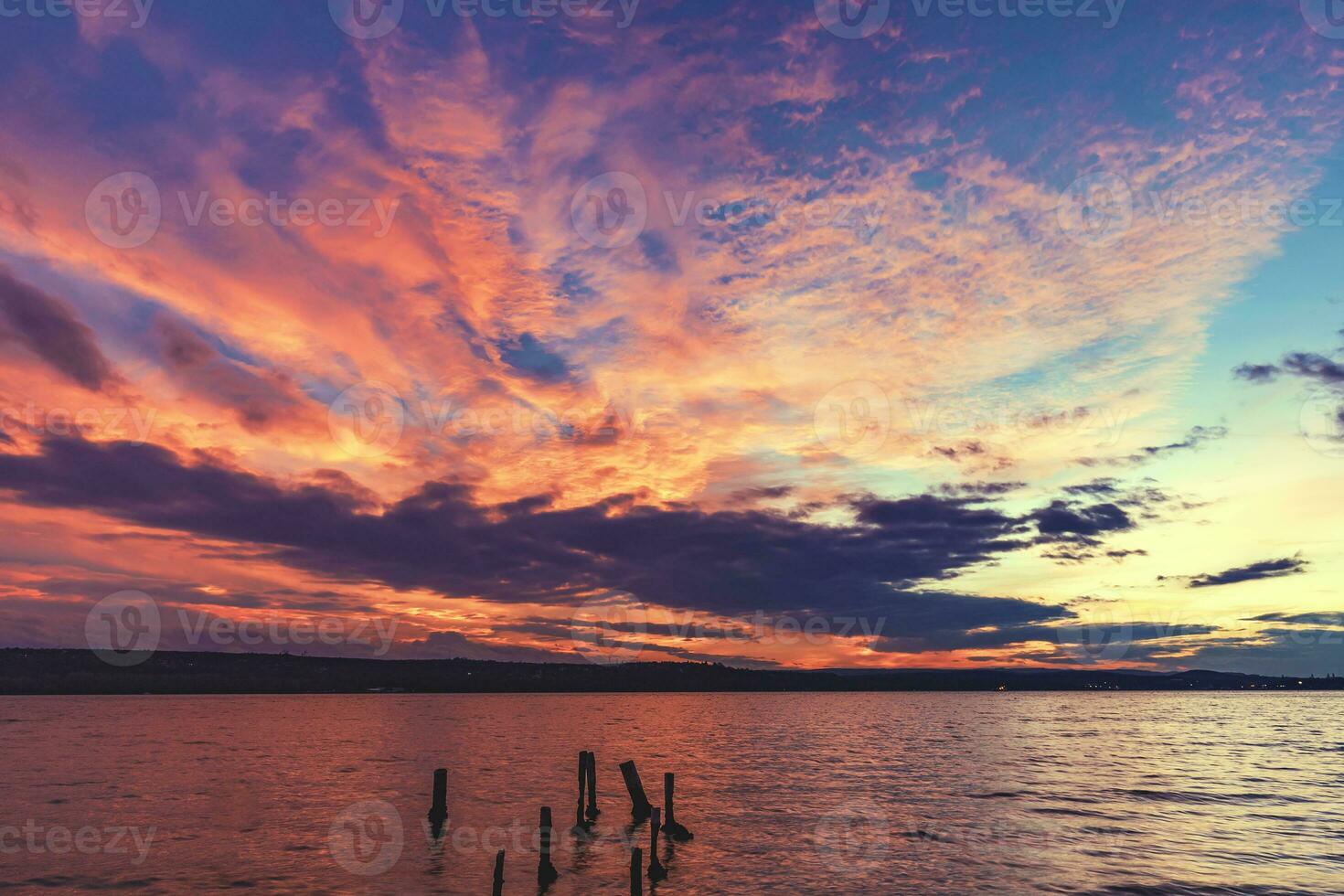 eccitante tramonto a il spiaggia. morto albero monconi nel il acqua foto