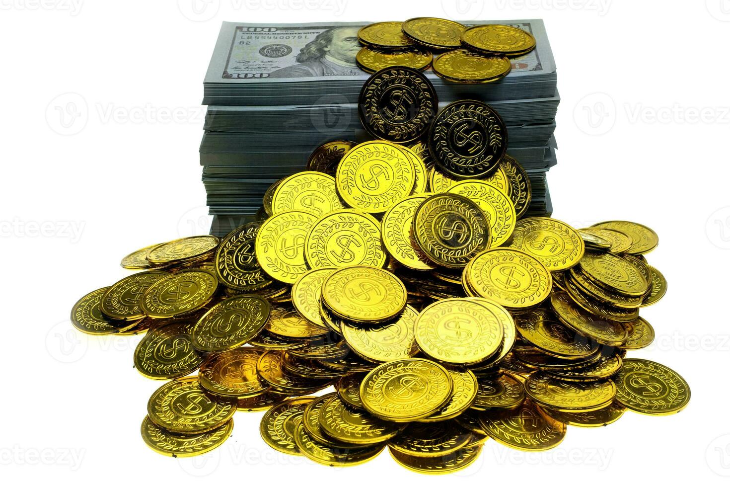 pila monete d'oro e banconote da 100 usd foto