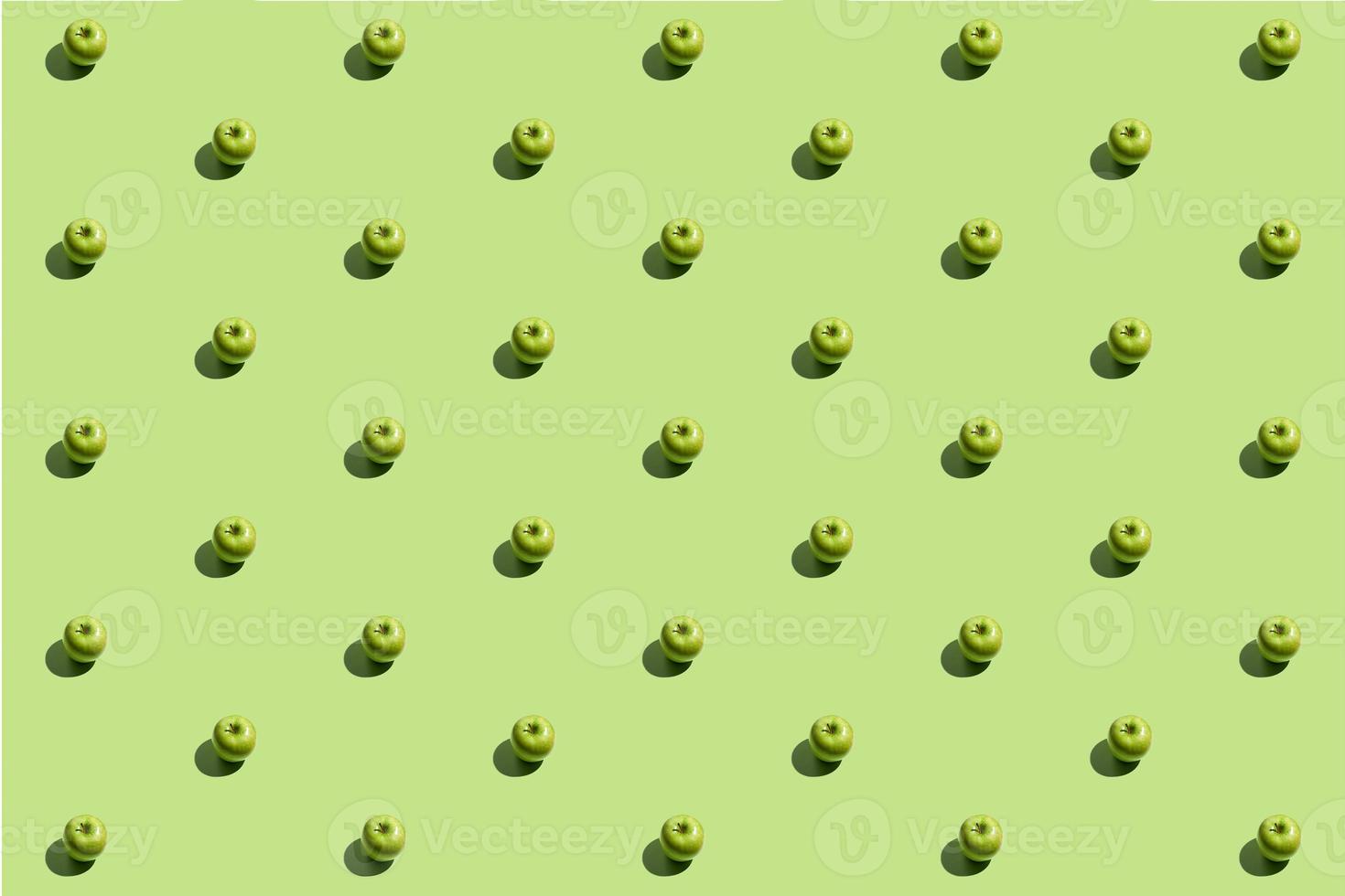 schema ripetitivo minimo fatto di mele verdi su sfondo verde foto