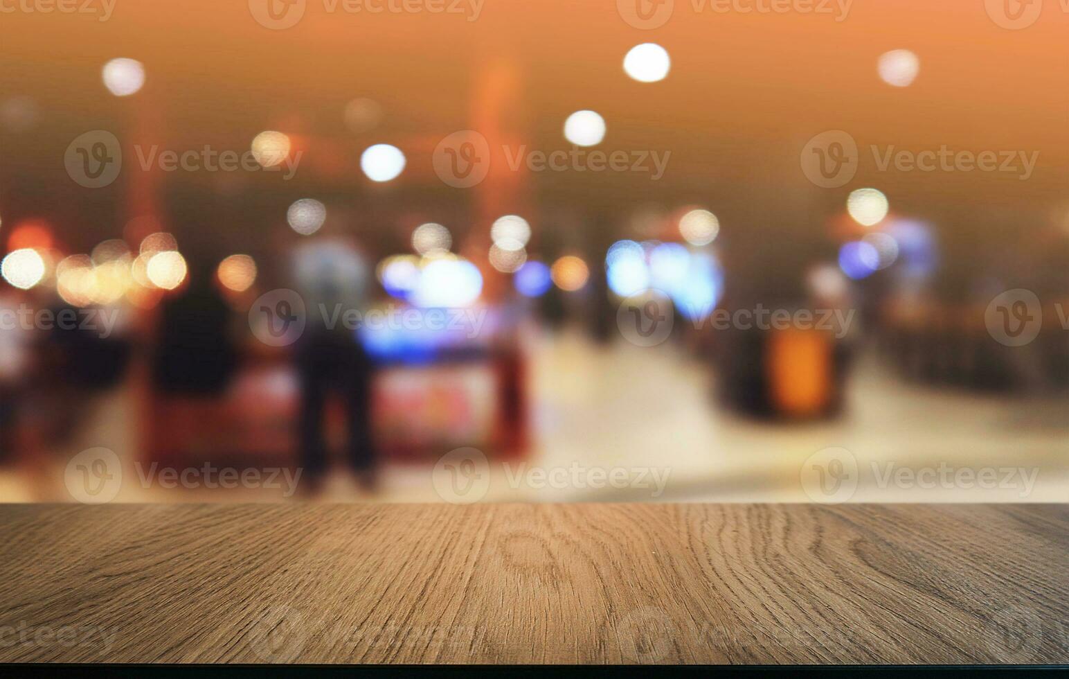 vuoto buio di legno tavolo nel davanti di astratto sfocato bokeh sfondo di ristorante . può essere Usato per Schermo o montaggio il tuo prodotti.mock su per spazio. foto