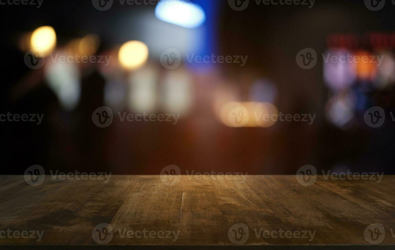 vuoto buio di legno tavolo nel davanti di astratto sfocato bokeh sfondo di ristorante . può essere Usato per Schermo o montaggio il tuo prodotti.mock su per spazio. foto