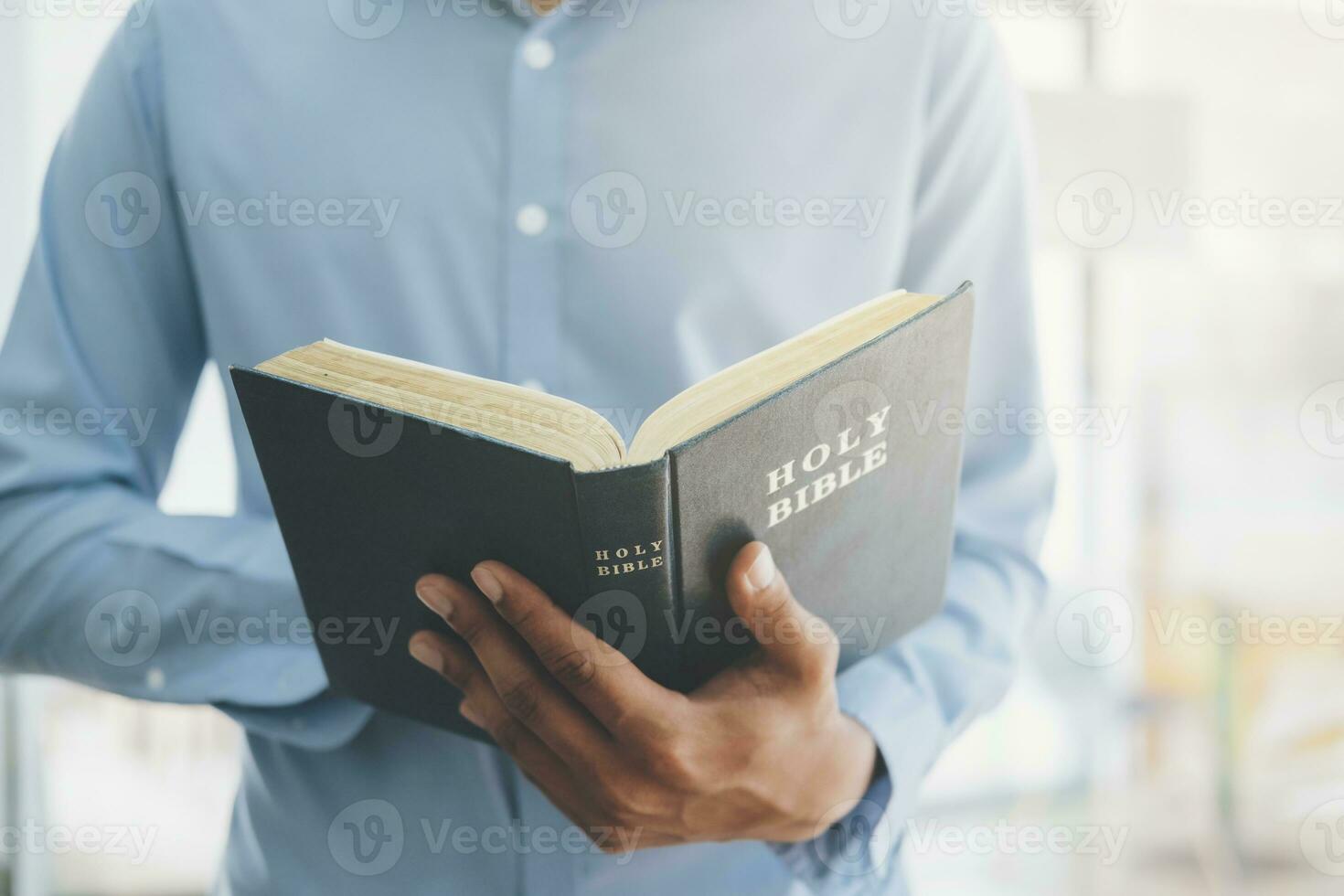 uomo Tenere e lettura il santo cristiano Bibbia. foto