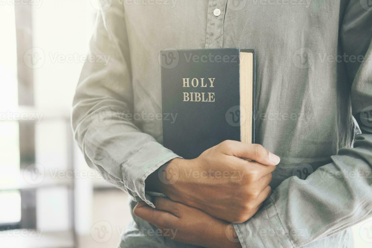 uomo Tenere e lettura il santo cristiano Bibbia. foto