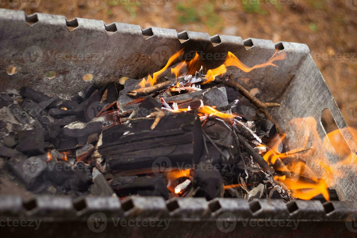 il fiamme nero carboni nel un' metallo griglia. foto