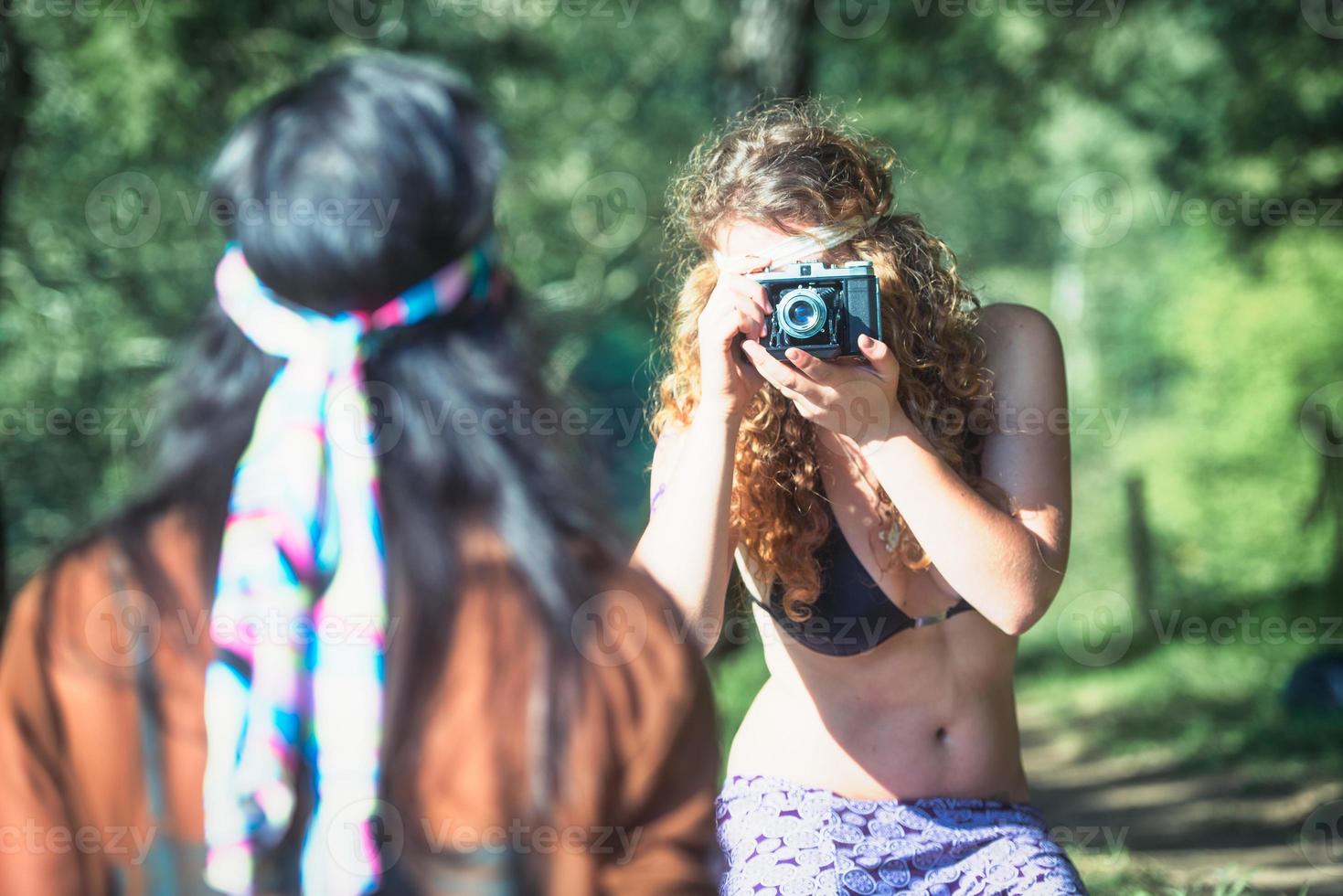 le ragazze in stile hippie si fotografano con una macchina fotografica vintage foto