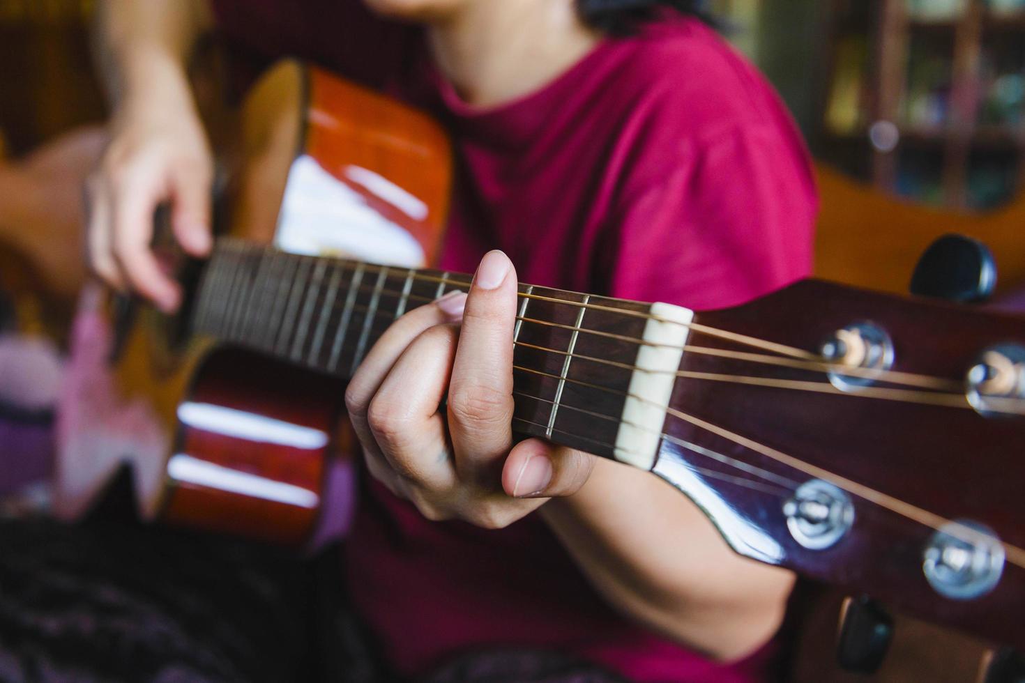 primo piano di un esecutore musicale maschile che suona sulla chitarra classica marrone. foto