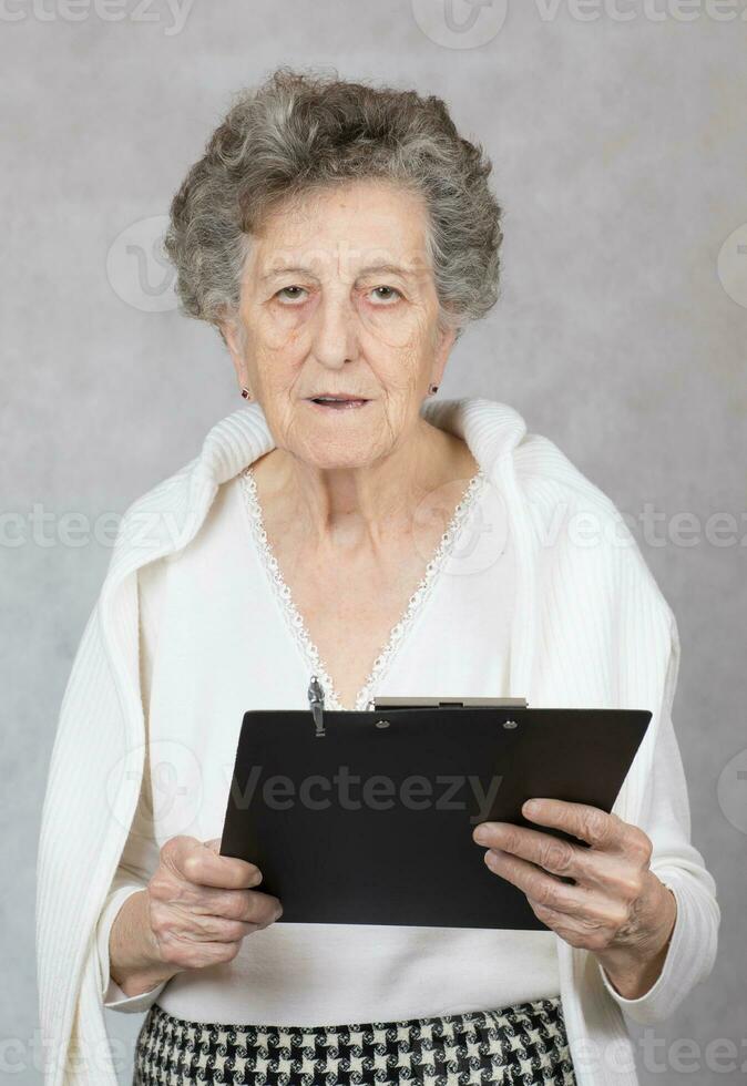 anziano vecchio donna a il grigio sfondo foto