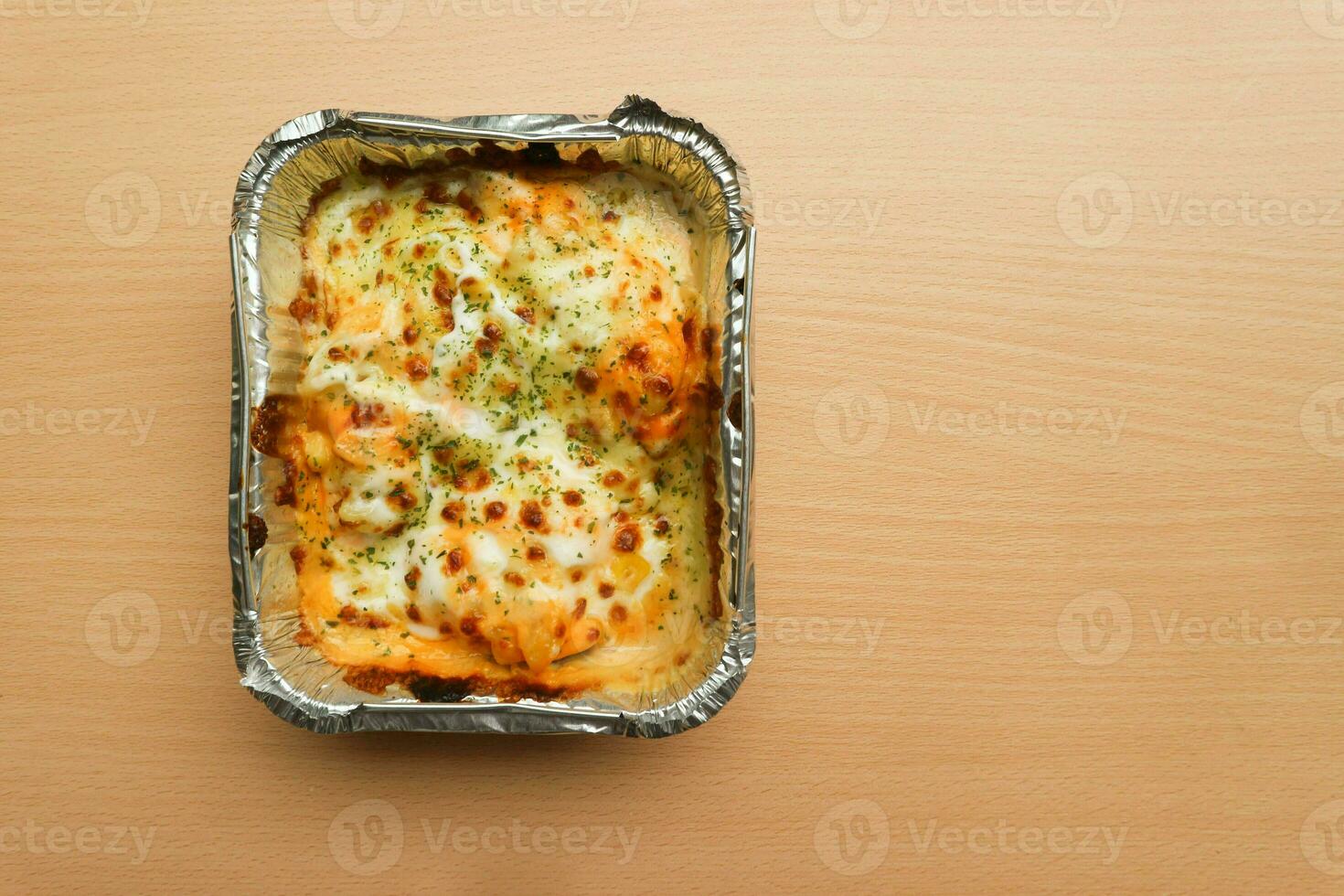 pasta maccheroni Saus keju o pasta Mac e formaggio nel il alluminio Foglio ciotola su il di legno sfondo foto