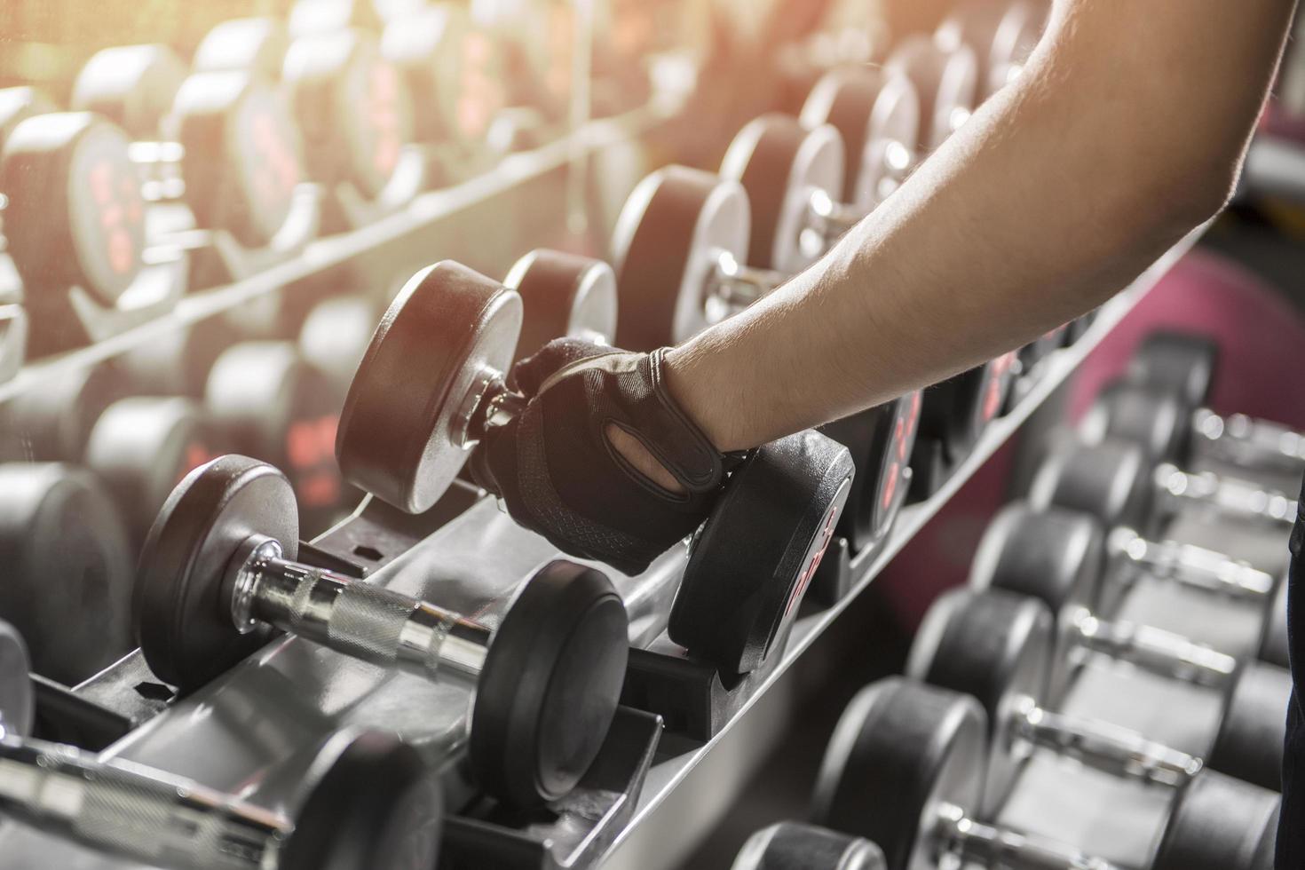 uomo che tiene il peso in palestra foto