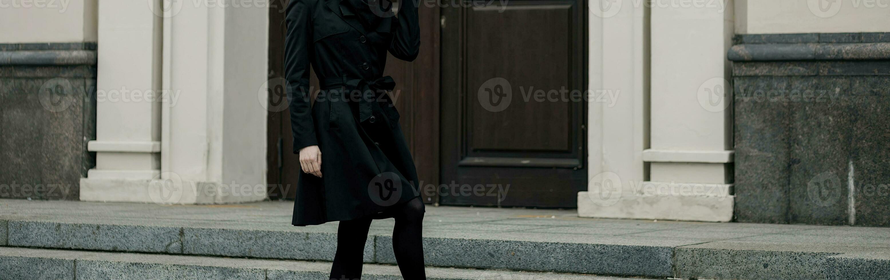elegante signora nel un' nero cappotto foto