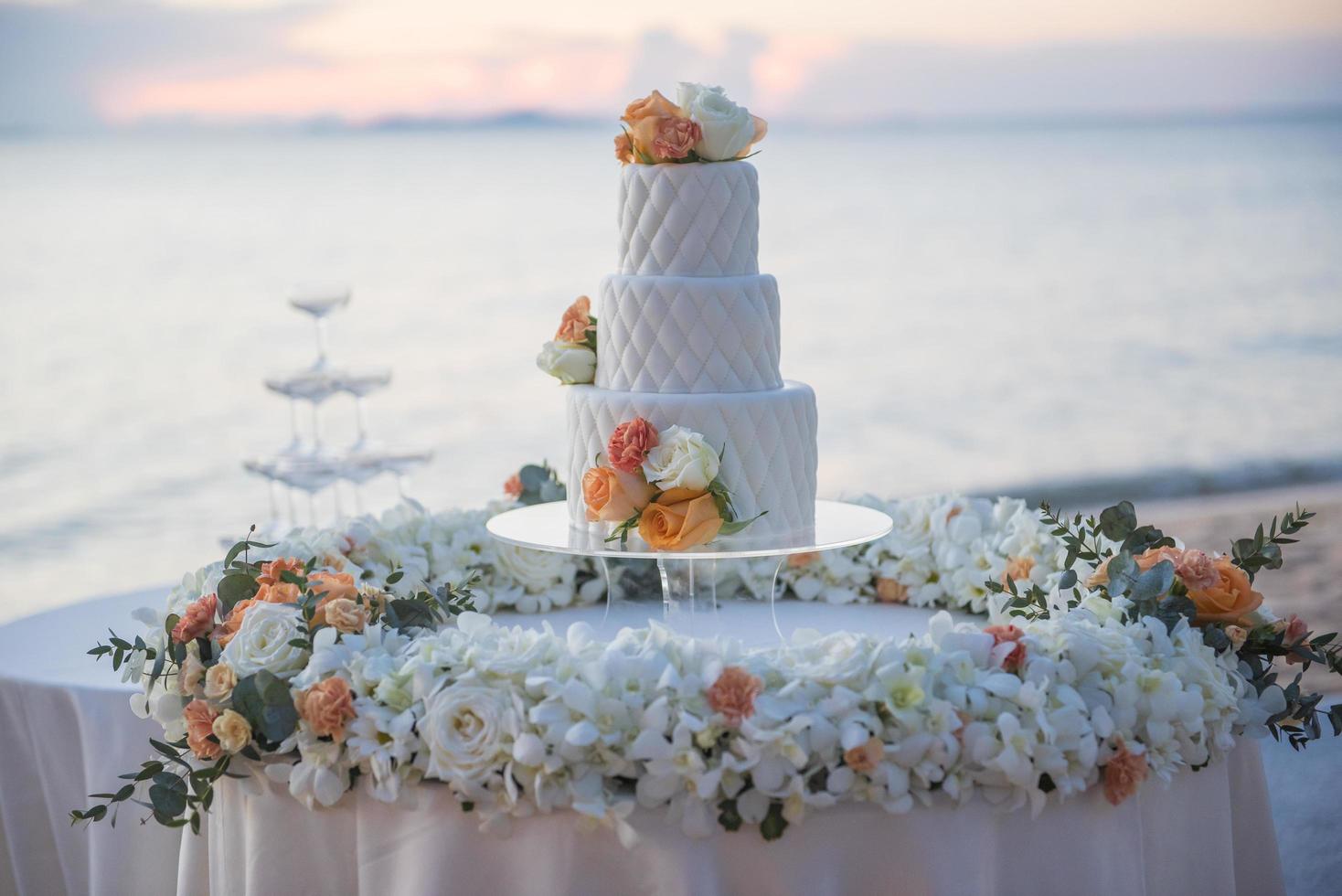 torta nuziale al matrimonio sulla spiaggia al tramonto foto