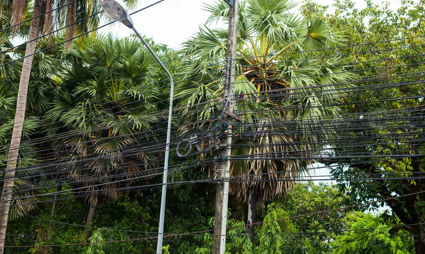 disordinato elettrico cavi nel Tailandia - scoperto ottico fibra tecnologia Aperto aria all'aperto asiatico città. foto
