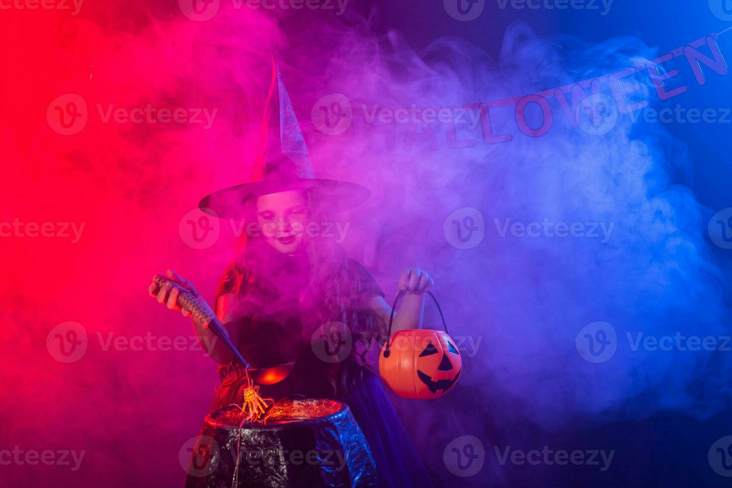 poco strega bambino cucinando pozione nel il calderone su Halloween. foto