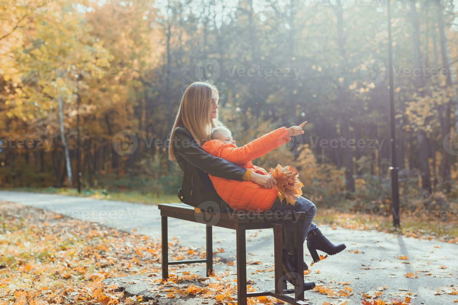 singolo genitore madre e bambino ragazzo nel il autunno nel parco sedersi su panca. autunno stagione e famiglia concetto. foto