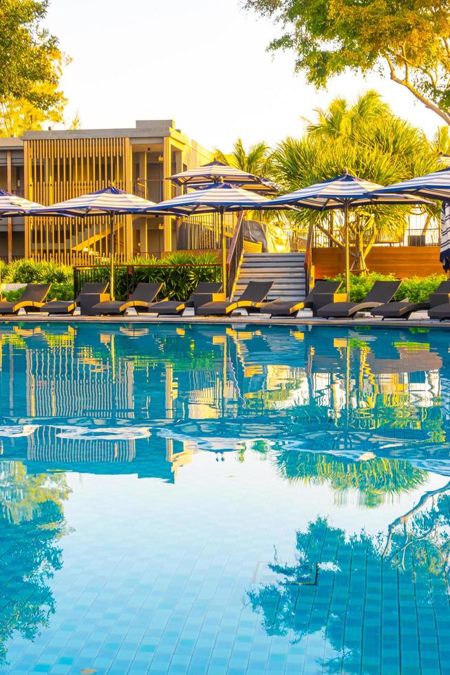 ombrellone e lettino intorno alla piscina all'aperto nel resort dell'hotel per le vacanze di viaggio foto