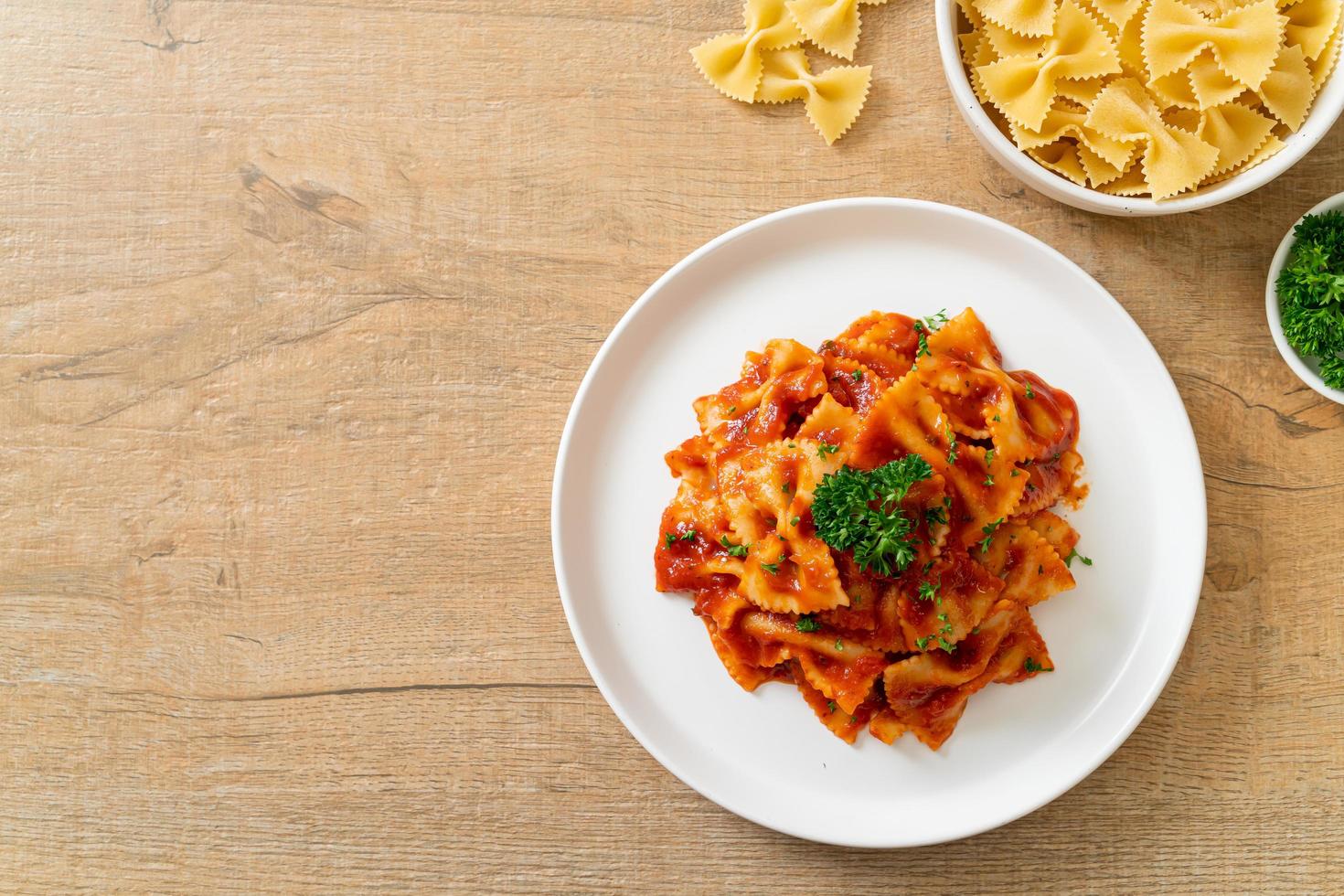 Farfalle in salsa di pomodoro con prezzemolo - Italian food style foto