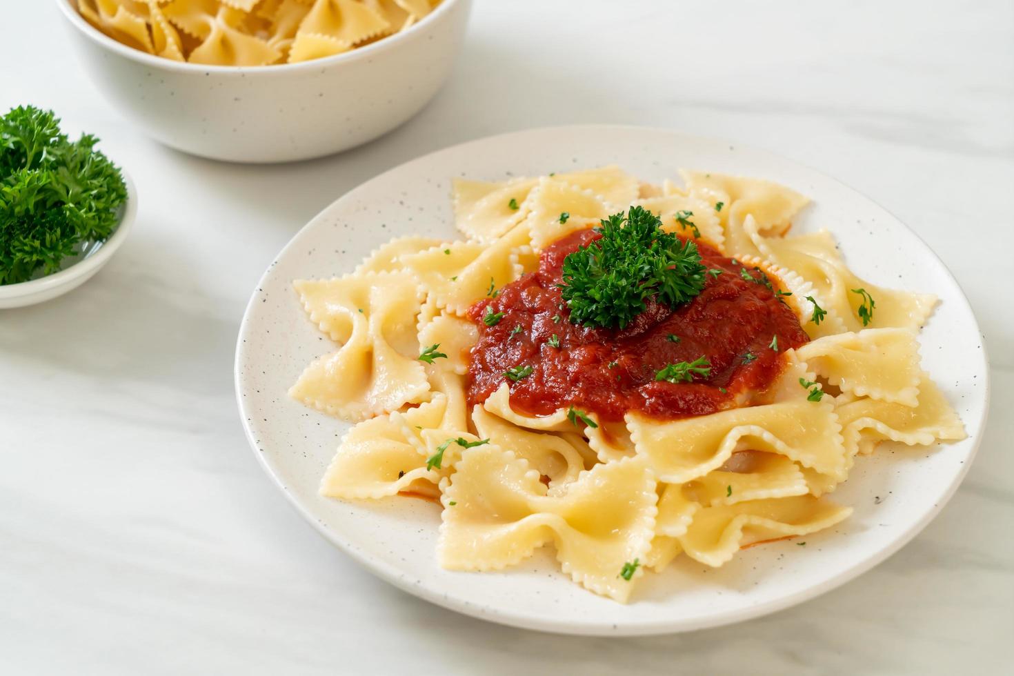 Farfalle in salsa di pomodoro con prezzemolo - Italian food style foto