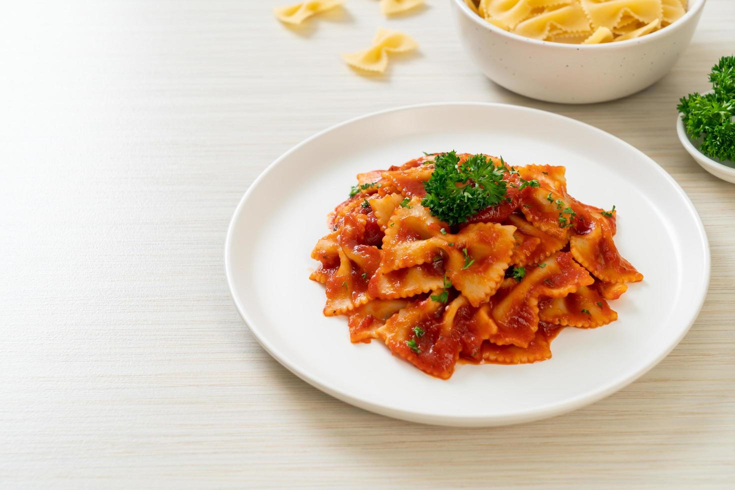 Farfalle in salsa di pomodoro con prezzemolo - Italian food style foto