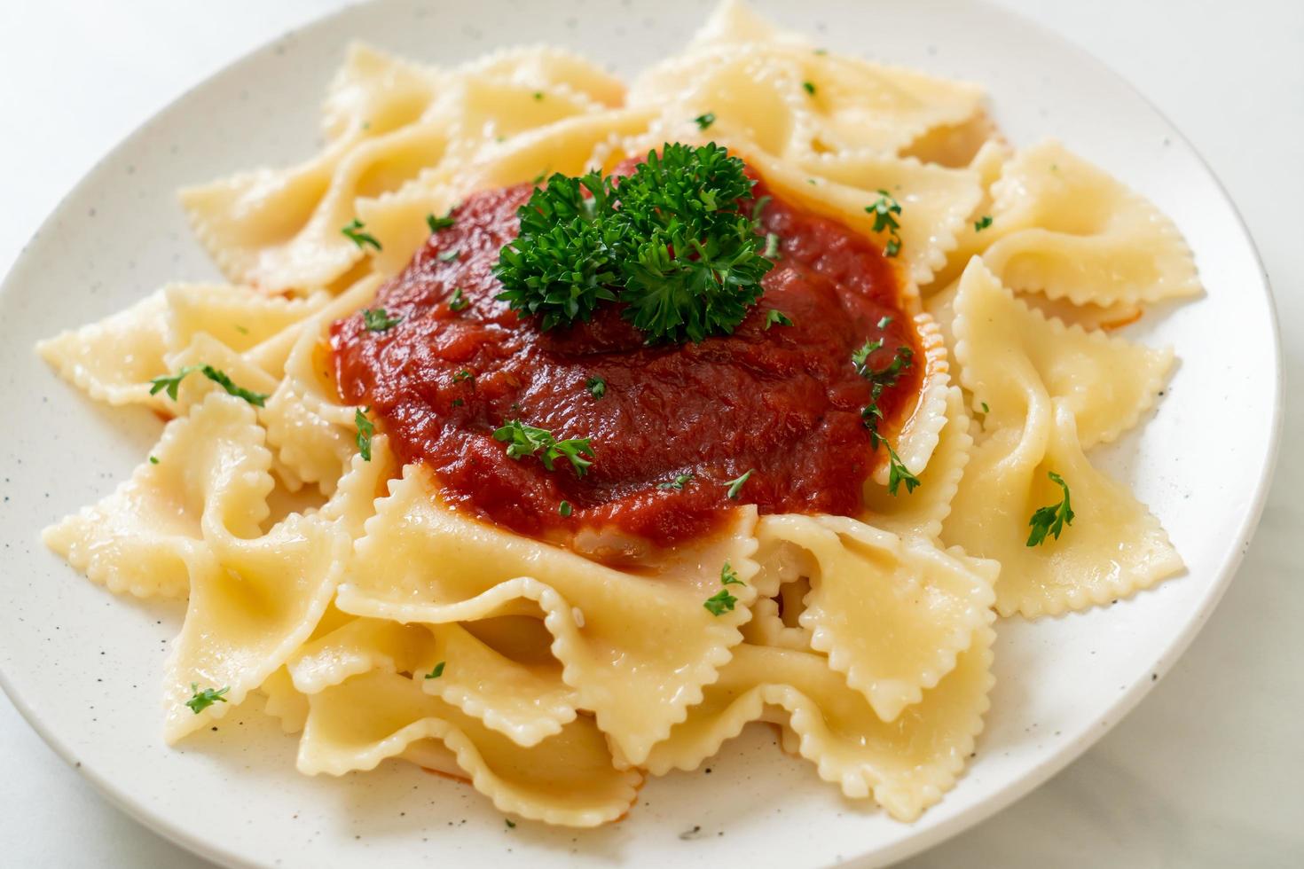 Farfalle in salsa di pomodoro con prezzemolo - Italian food style foto