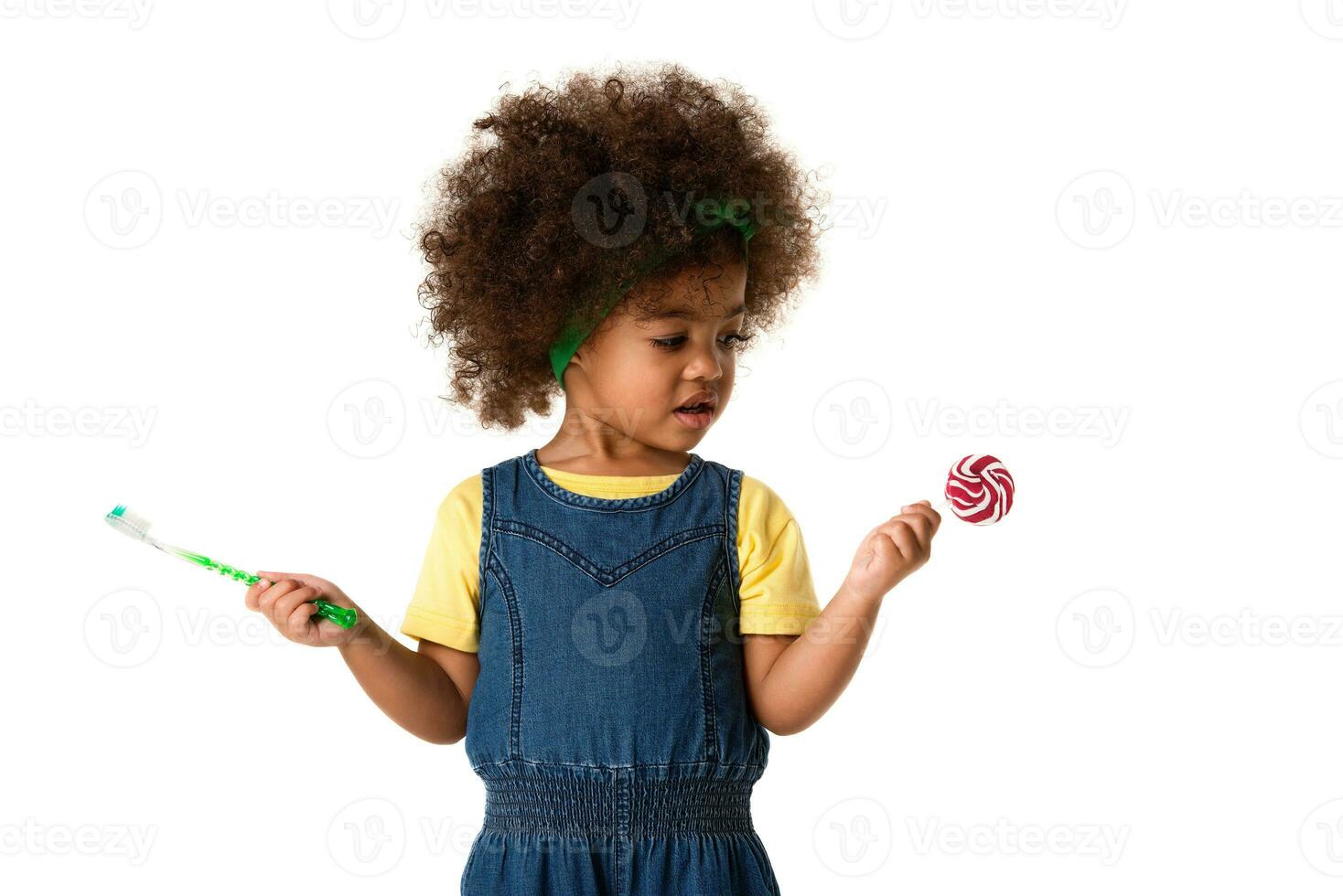 infanzia e persone concetto- bello africano americano poco ragazza con spazzolino e dolce lecca-lecca. salutare denti concetto. malsano cibo. foto
