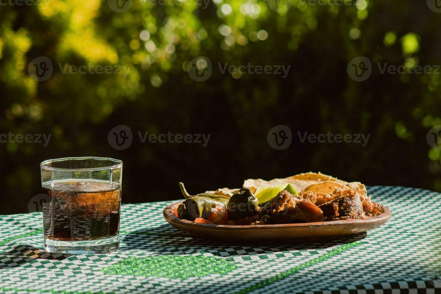 il messicano Carnitas, un' delizioso cibo, è servito con vario condimenti su un' tavolo con vasellame foto