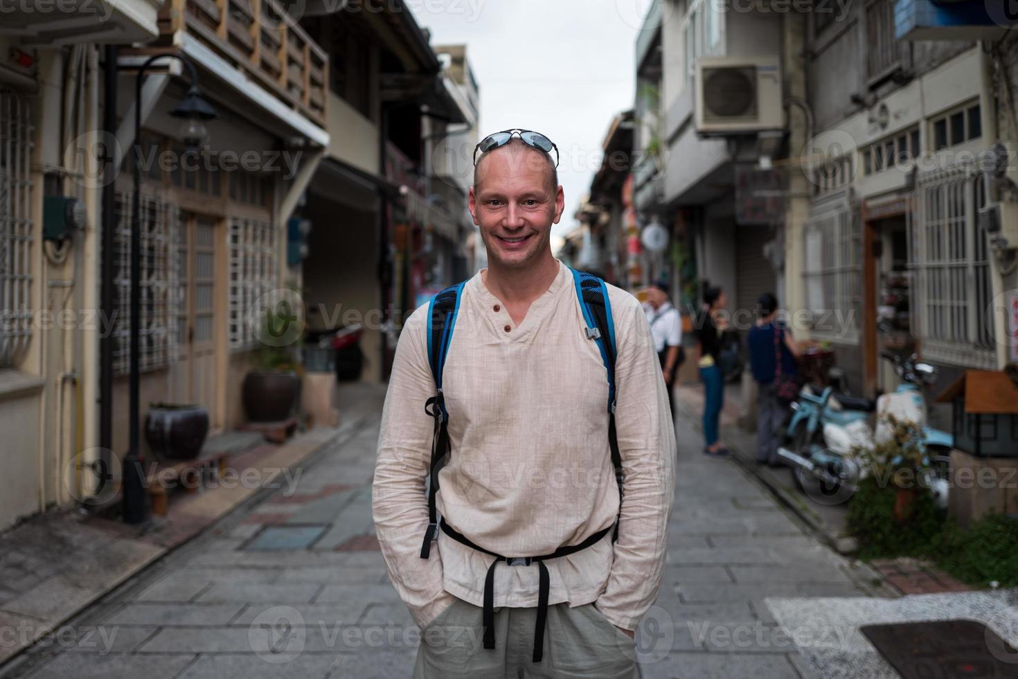 uomo caucasico sorridente per le strade di tainan a tainan foto