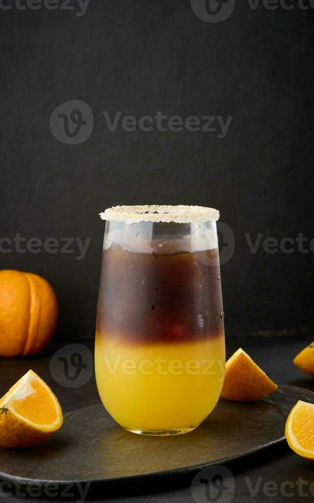 ghiacciato caffè con arancia succo nel un' trasparente bicchiere, rinfrescante Bumble caffè su il tavolo foto