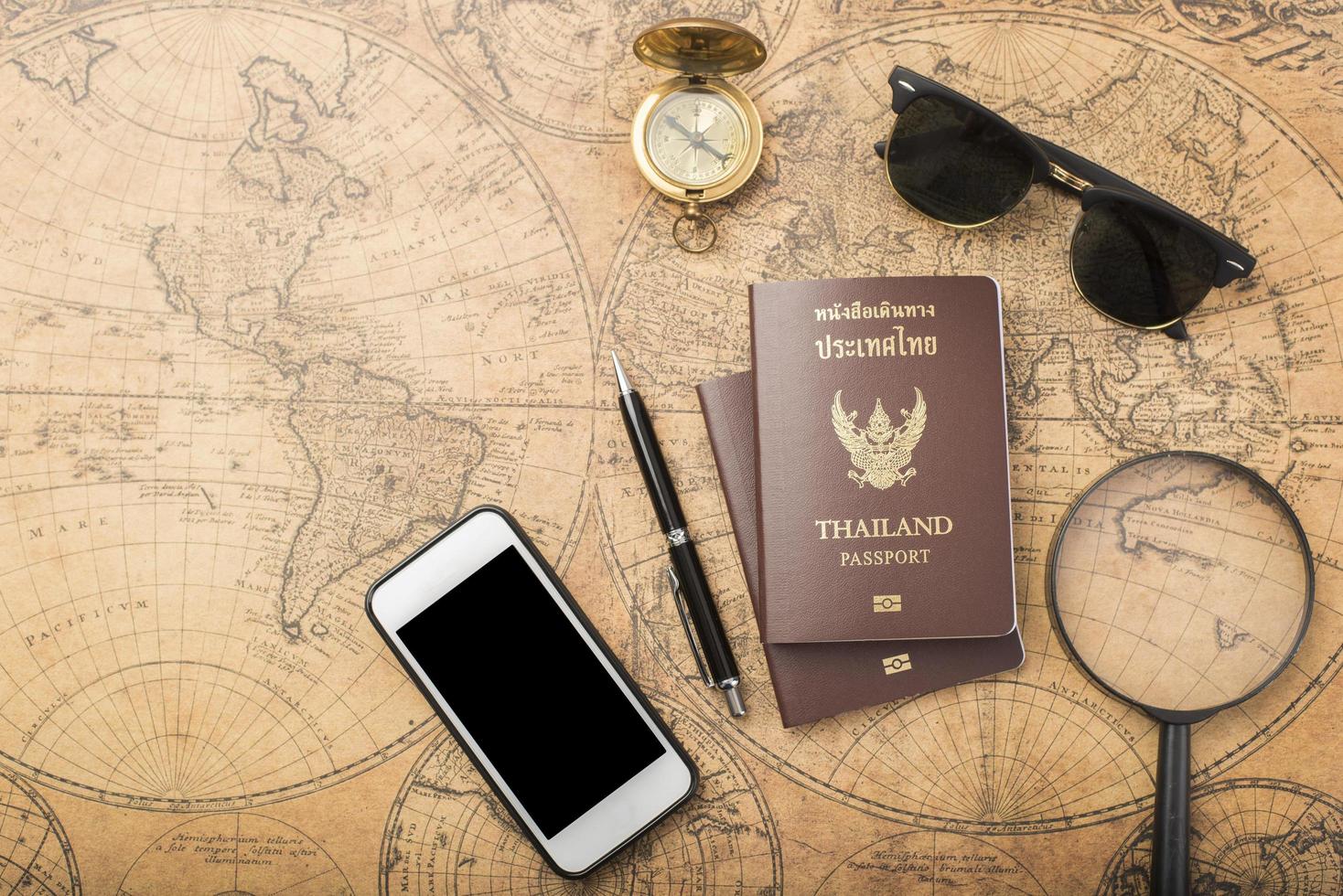 pianificazione del concetto di viaggio, passaporto thailandese sulla vecchia mappa foto