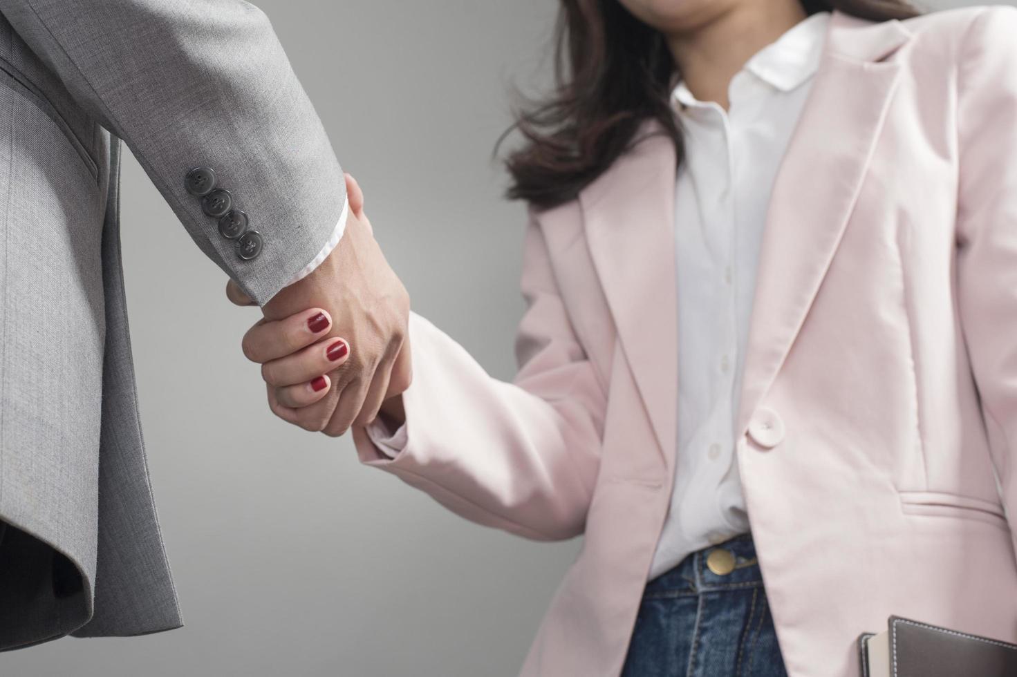 uomo d'affari e donna d'affari si stringono la mano, piano aziendale e concetto di riunione d'affari foto