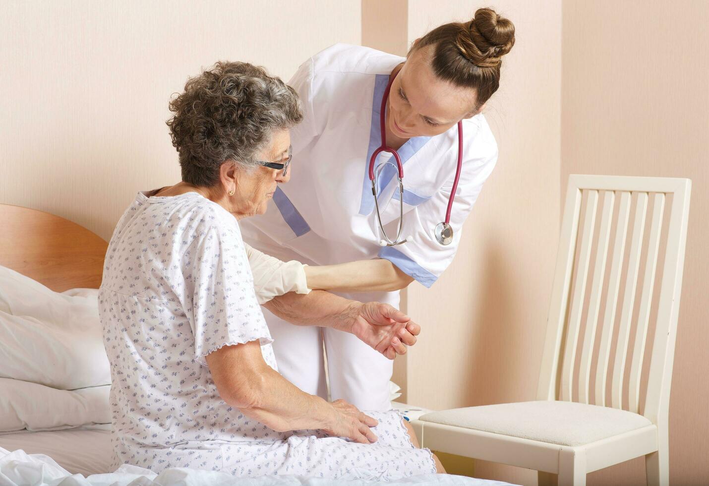 geriatra aiuta un' anziano donna per In piedi su foto