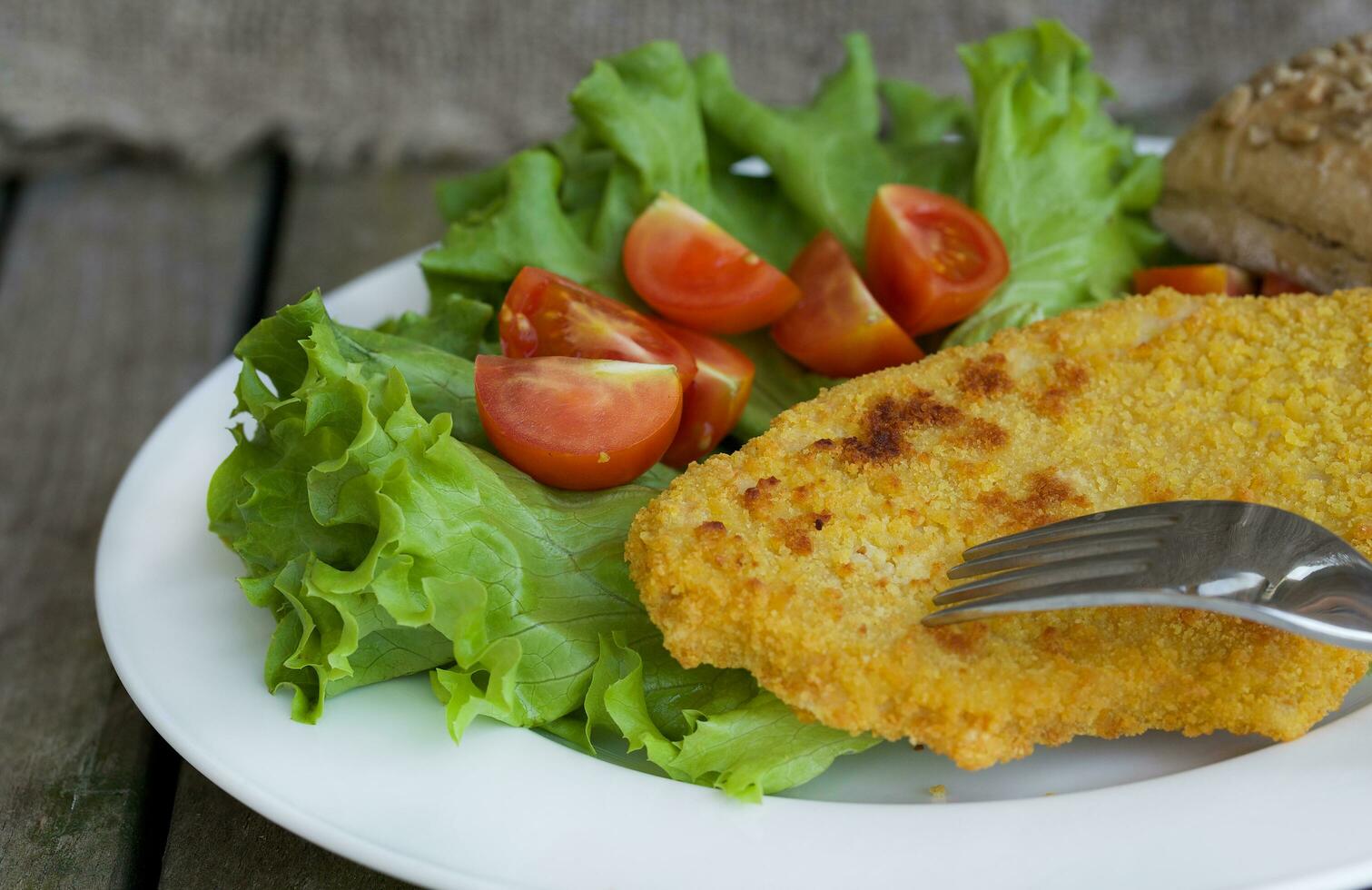 pollo cotoletta con ciliegia pomodori e verde insalata le foglie. foto