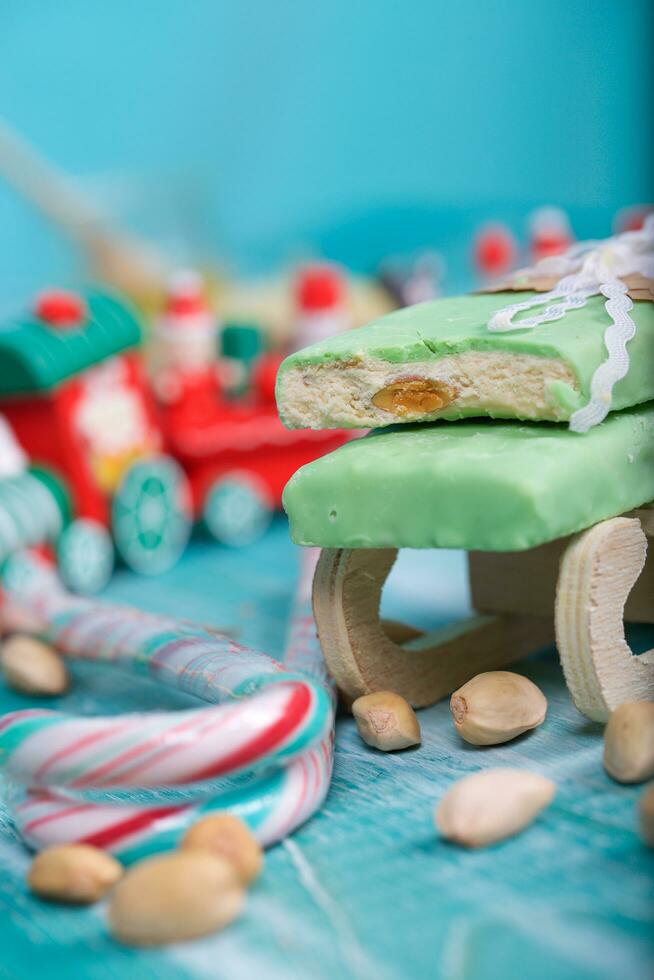 mandorla torrone coperto di pistacchio cioccolato su un' di legno superficie. foto