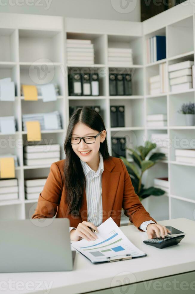 asiatico donna d'affari Lavorando nel il ufficio con Lavorando bloc notes, tavoletta e il computer portatile documenti nel ufficio foto