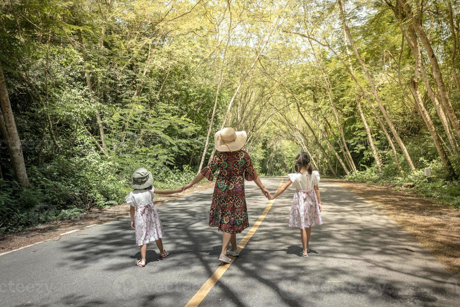 madre e figlie che camminano in un parco foto