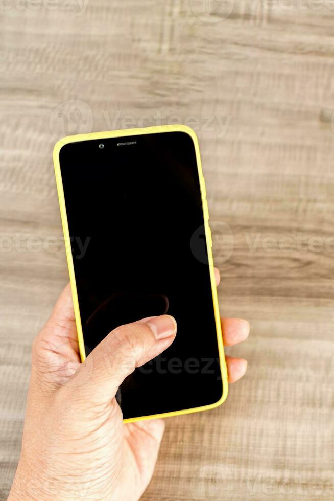 superiore Visualizza modello Immagine di un' mani Tenere mobile Telefono con vuoto nero schermo. foto