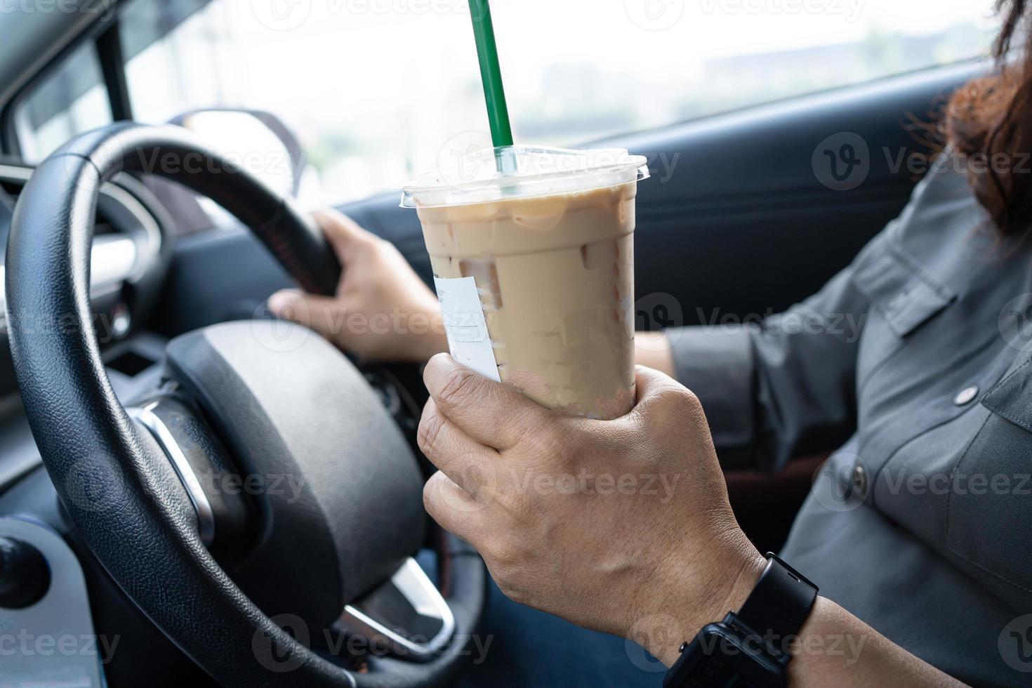 signora asiatica che tiene il caffè freddo in macchina pericoloso e rischia un incidente. foto