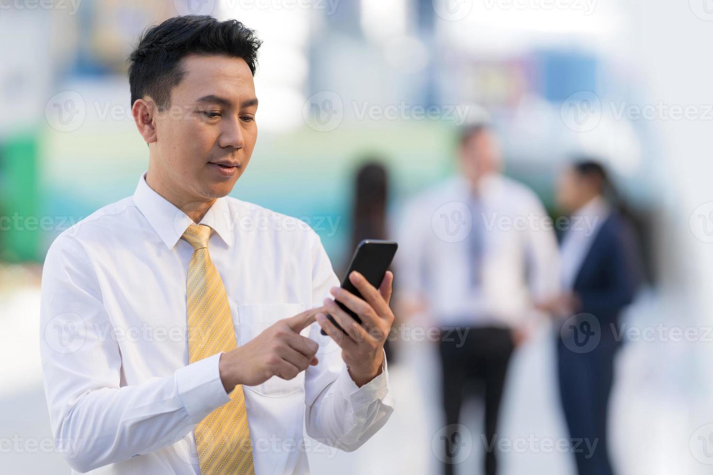 ritratto di uomo d'affari sorridente che usa un telefono foto