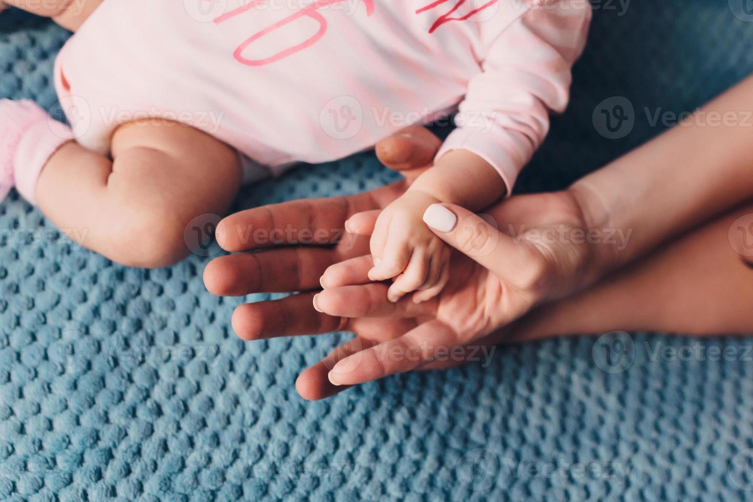 mamma e papà tengono la mano del bambino. maniglia per bambini foto