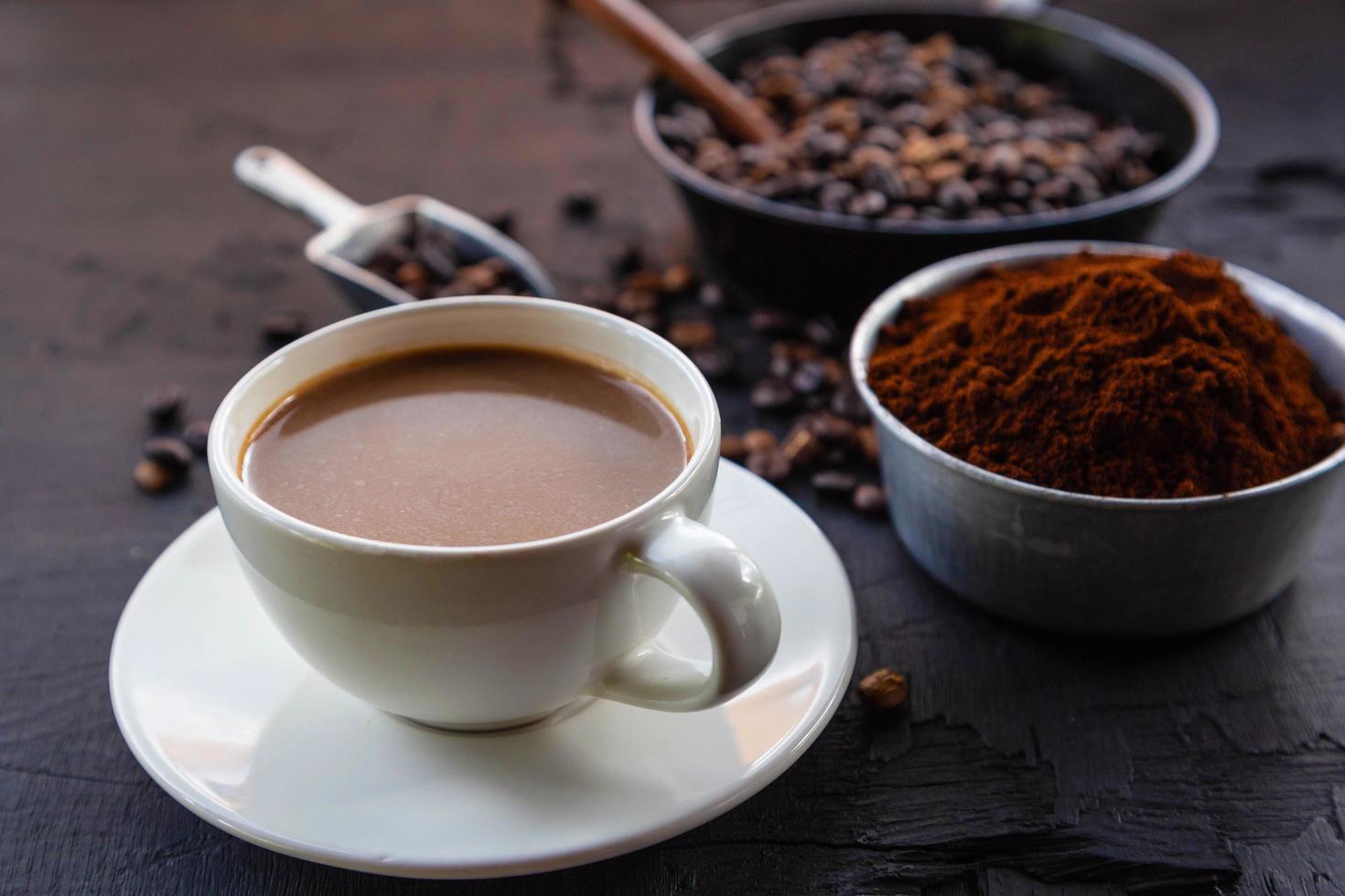 chicchi di caffè tostati con polvere di caffè e tazzine. foto