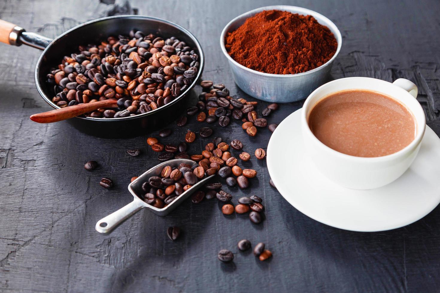 chicchi di caffè tostati con polvere di caffè e tazzine. foto