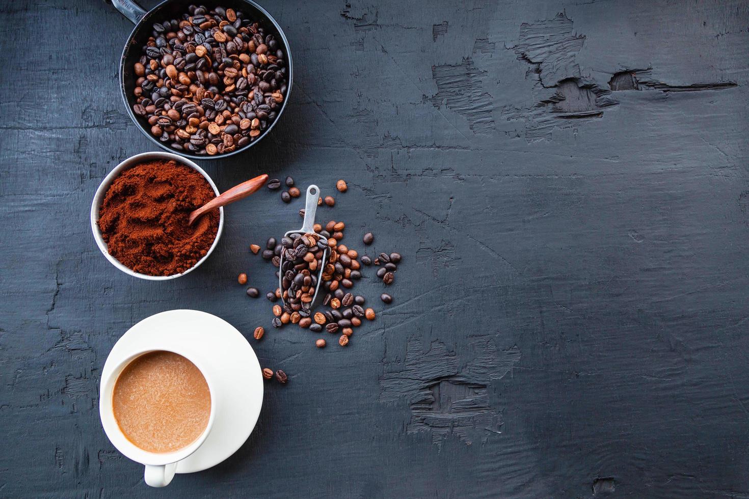 chicchi di caffè tostati con polvere di caffè e tazzine. foto