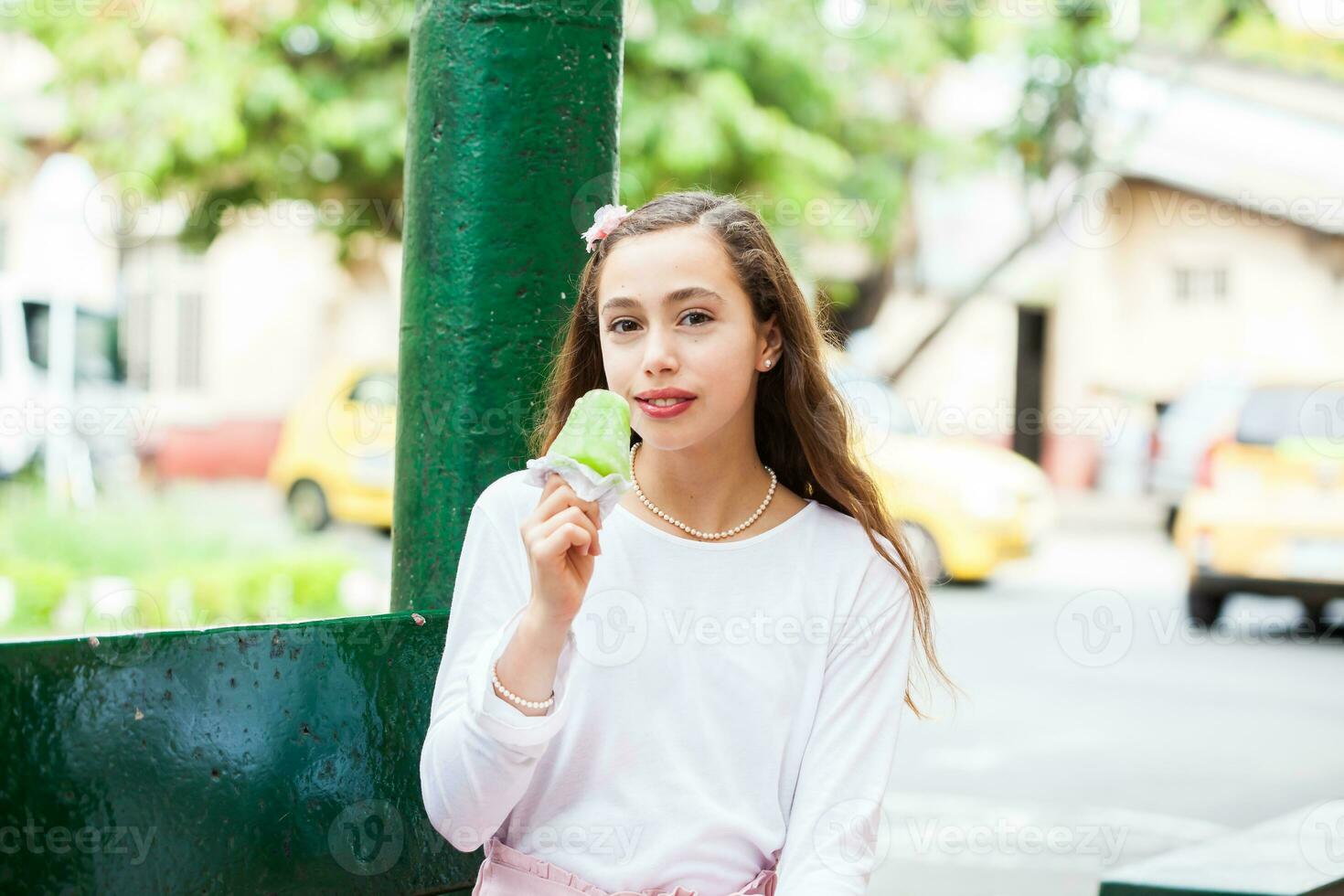 giovane ragazza mangiare un' tradizionale acqua ghiaccio crema tipico di il Valle del cauca regione nel Colombia foto